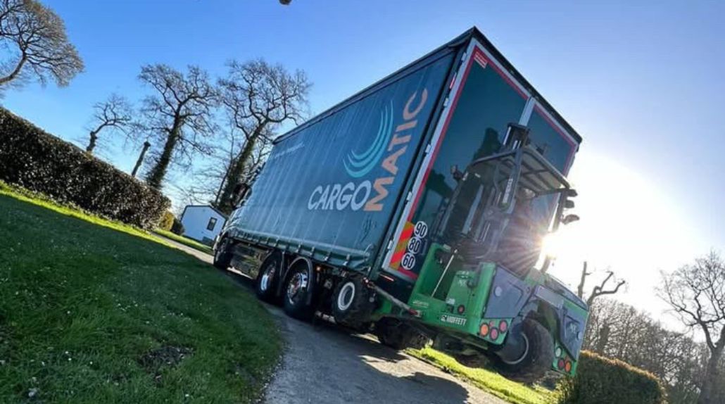 Camion Cargomatic avec chariot embarqué électrique réalisant une livraison directe d'un abri dans un camping
