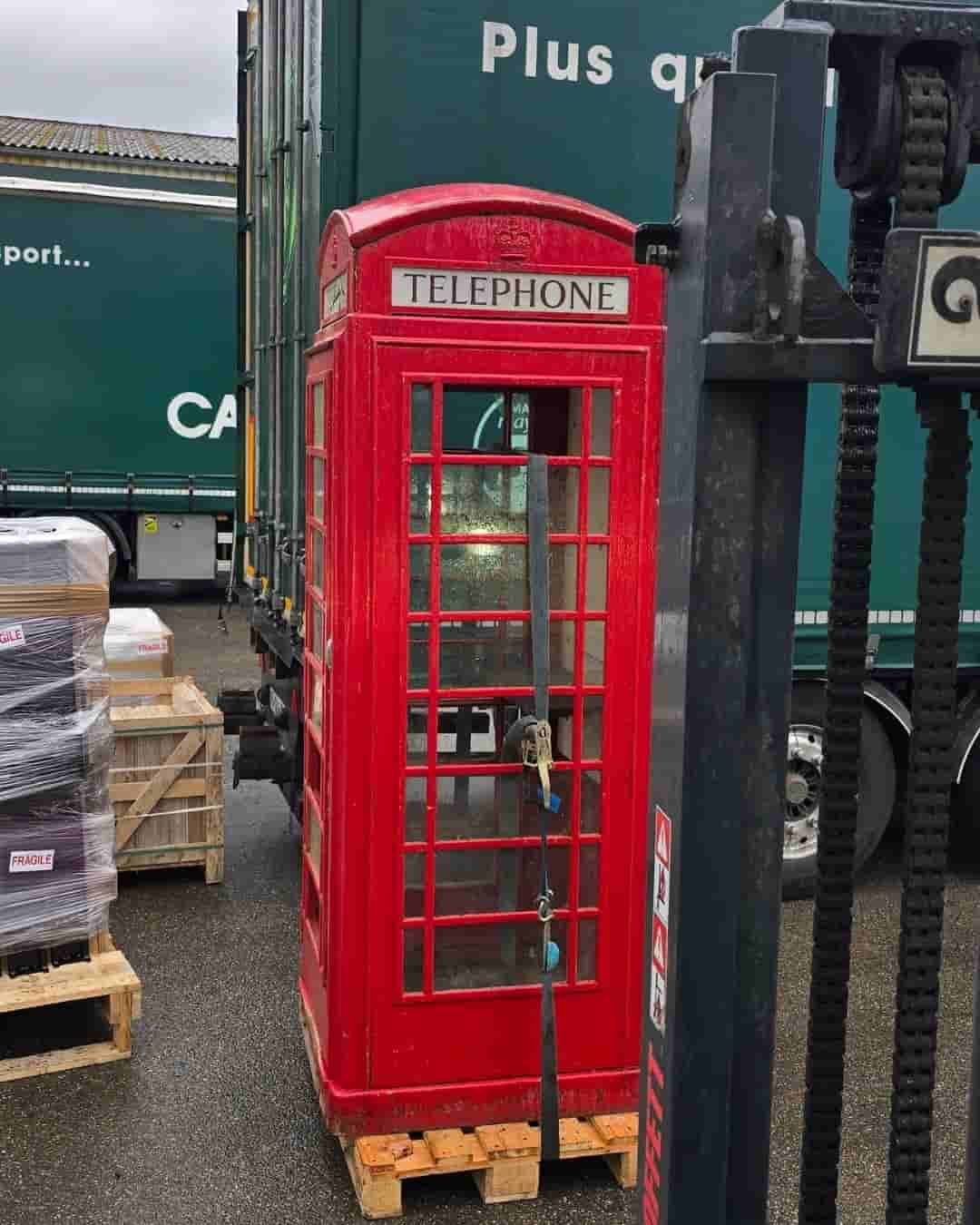 Cabine téléphonique anglaise transportée sur palette par Cargomatic pour une livraison directe à domicile avec chariot embarqué