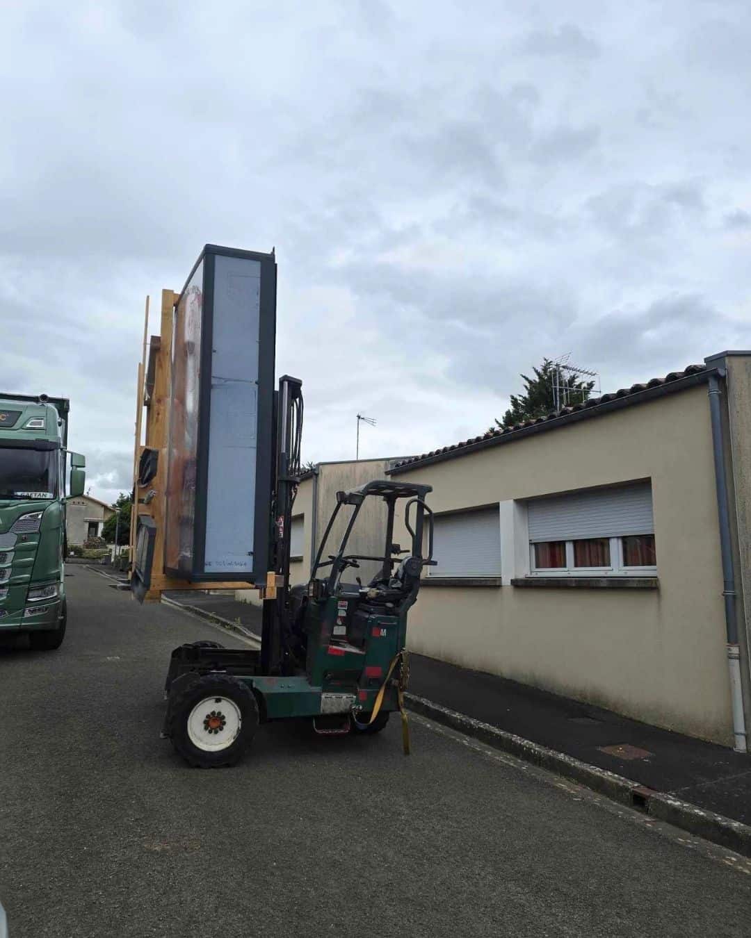 Livraison directe d'un abri de piscine en milieu urbain par camion équipé d'un chariot embarqué Cargomatic