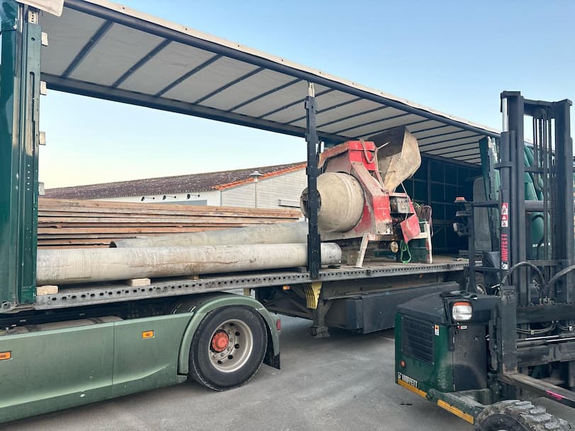 Camion Cargomatic transportant une bétonnière et des tuyaux pour la rénovation d'un terrain de tennis à Loix
